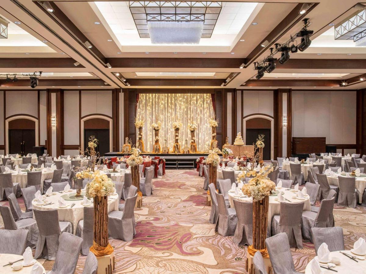 Paradox Singapore Merchant Court At Clarke Quay Exterior photo The photo depicts an elegant banquet hall set up for an event. The room features numerous round tables draped in white and gray tablecloths, each adorned with floral centerpieces. The chairs are covered in gray fabric with white accents. At the front