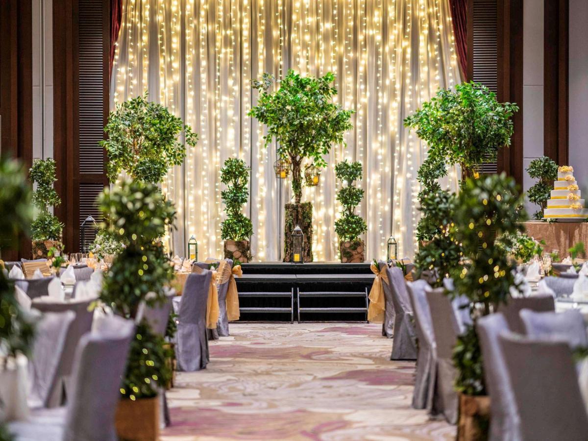 Paradox Singapore Merchant Court At Clarke Quay Exterior photo The photo shows a beautifully decorated event space, likely set up for a wedding or a formal gathering. The scene features:

- A backdrop of draped fabric embellished with twinkling fairy lights, creating a romantic ambiance.
- Several potted greener