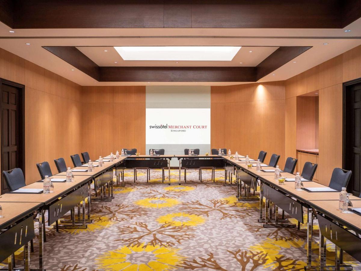 Paradox Singapore Merchant Court At Clarke Quay Exterior photo The image shows a professional conference room designed for meetings. It features a large rectangular arrangement of tables with black chairs surrounding them. The walls are made of light-colored wood, contributing to a modern and sophisticated atmos