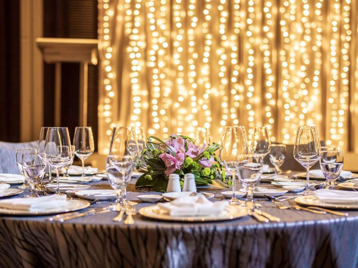 Paradox Singapore Merchant Court At Clarke Quay Exterior photo The image shows a beautifully set dining table, elegantly arranged for a special event or celebration. The table is covered with a stylish cloth, and there are several plates, glasses, and utensils neatly placed around it. In the center, there's a fl