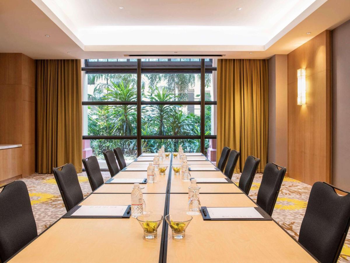 Paradox Singapore Merchant Court At Clarke Quay Exterior photo The photo shows a conference room set up for a meeting. There is a long rectangular table with chairs on both sides. Each place setting has a notepad, pen, and a small glass of water. The room features large windows with plants visible outside, along