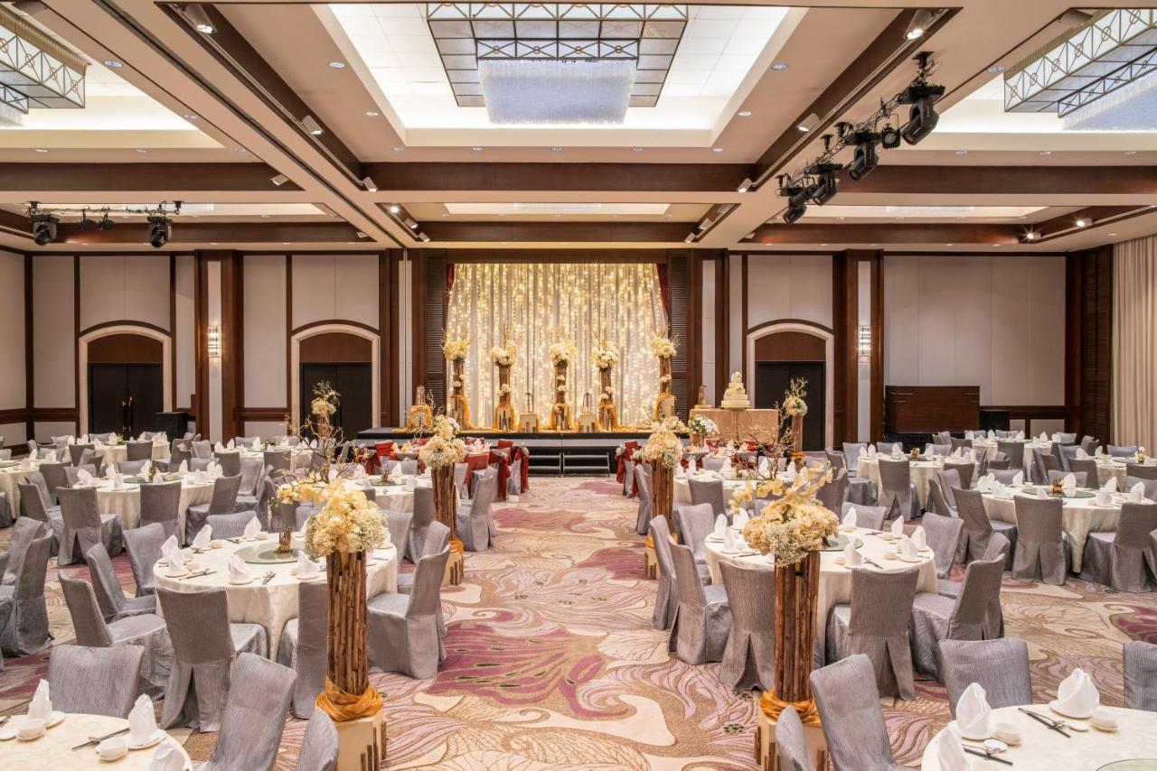 Paradox Singapore Merchant Court At Clarke Quay Exterior photo The photo shows an elegantly arranged banquet or event hall. There are several round tables covered with white tablecloths and decorated with floral centerpieces, creating a sophisticated atmosphere. The chairs are covered in grey fabric, complementi