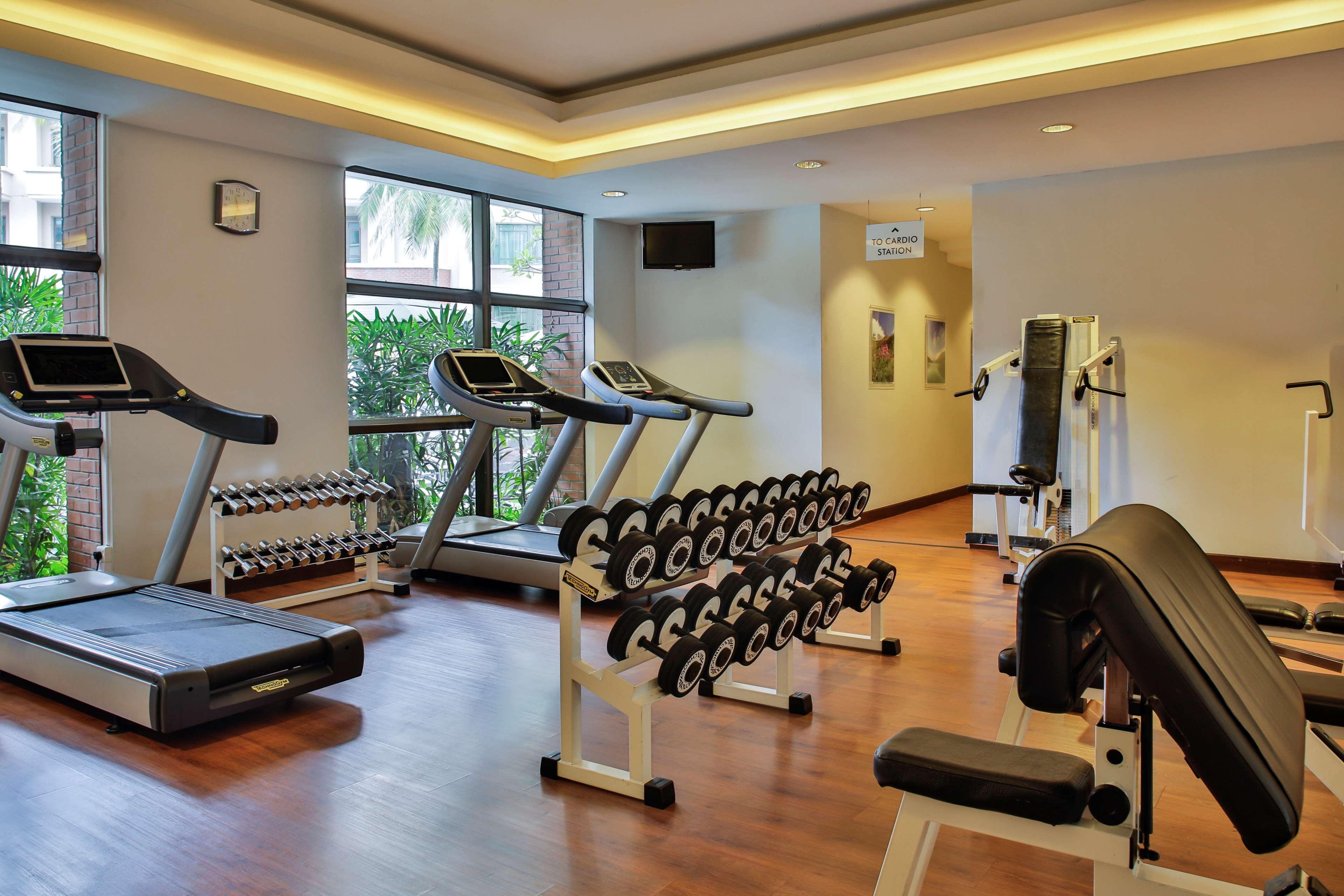 Paradox Singapore Merchant Court At Clarke Quay Exterior photo The photo shows a gym or fitness area featuring various exercise equipment. There are two treadmills positioned near a window, allowing natural light to brighten the space. A set of dumbbells is neatly organized on a rack, prominently displayed. Addi