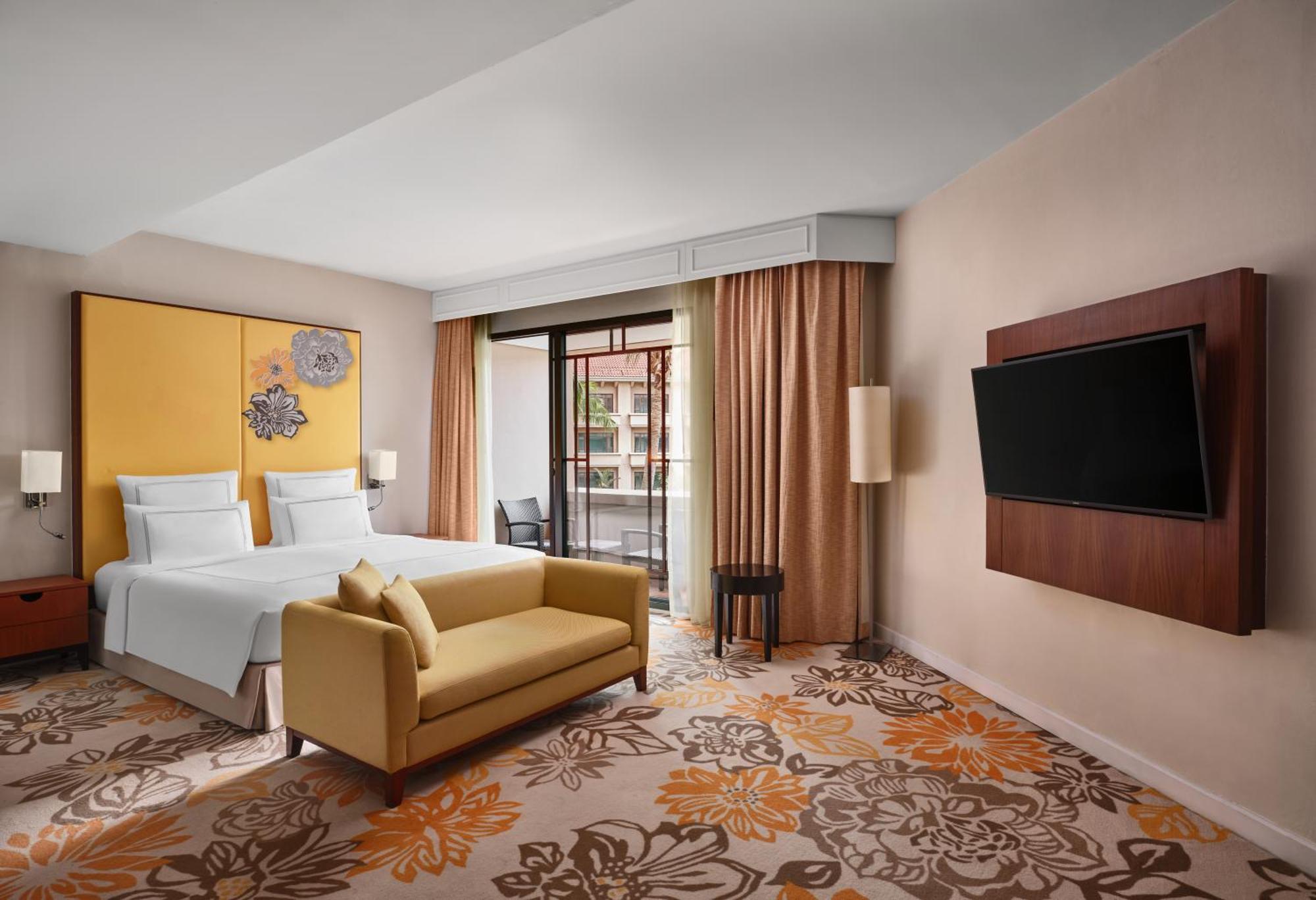 Paradox Singapore Merchant Court At Clarke Quay Exterior photo The photo shows a modern hotel room featuring:

- A queen or king-sized bed with white bedding against a bright yellow wall.
- A cozy yellow sofa placed in front of the bed.
- A plush carpet with floral designs in warm colors.
- Large windows with be